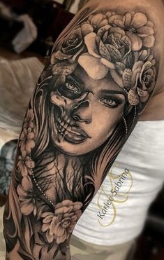 a woman's half sleeve with roses and skulls on her arm, in black and white