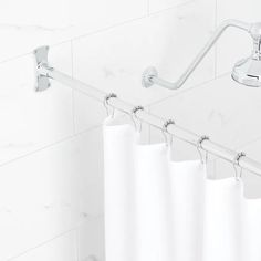 a white shower curtain hanging on the side of a bathtub with handles and bars