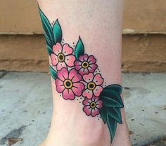 a woman's foot with pink flowers and green leaves on the bottom of it