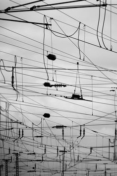 black and white photograph of electrical wires in the sky