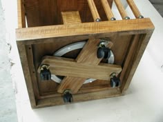 a wooden box with wheels and plates in it