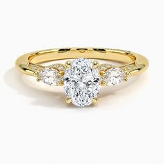 a yellow gold engagement ring with three pear shaped diamonds