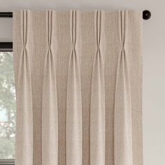 an open window with beige curtains hanging on the curtain rod and valil in front of it