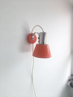 an orange lamp is on the wall next to a window