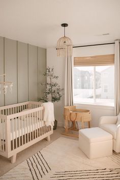 a baby's room with a crib, chair and ottoman