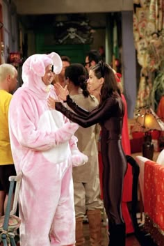 two people dressed in pink and black standing next to each other on the set of friends tv show