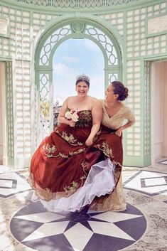 two women in dresses are posing for the camera