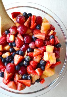 a glass bowl filled with fruit and berries