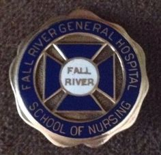 a badge that says fall river general hospital school of nursing on the side of a carpeted floor