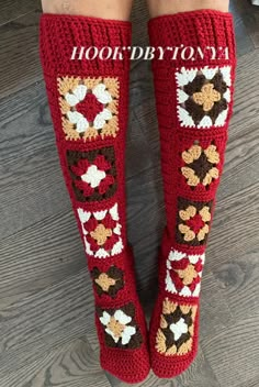 the legs of a woman wearing red crocheted leg warmers with flowers on them