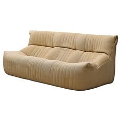 a beige couch sitting on top of a white floor