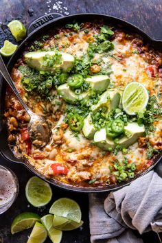 a skillet filled with mexican food and garnished with avocado slices