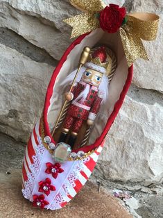 a nutcracker in a red and white case with gold trim on it's head