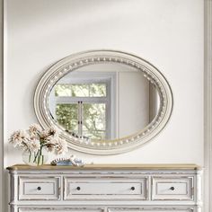 a white dresser and mirror in a room