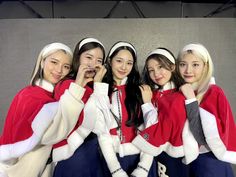 four girls dressed in red and white posing for the camera