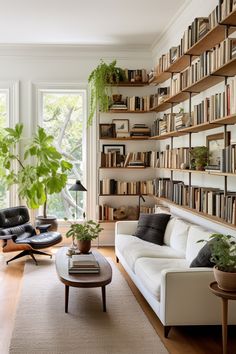 a living room filled with furniture and bookshelves full of books next to a window