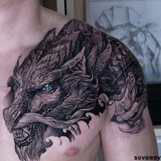 a man's chest with a dragon tattoo on his left side and blue eyes