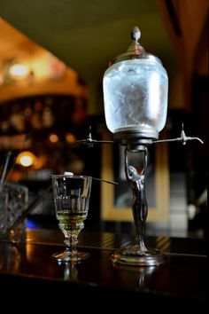 an ice bucket sitting on top of a table next to a glass filled with liquid