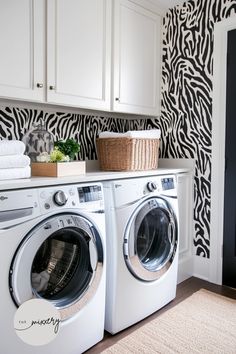 a washer and dryer in a room with zebra print wallpaper on the walls