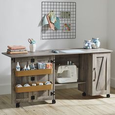 a sewing machine sitting on top of a wooden table next to a wall mounted art piece