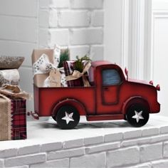 a red toy truck with presents in the back