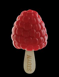 a red gummy ball on top of a wooden stick