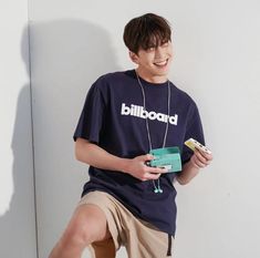 a young man sitting on top of a white wall