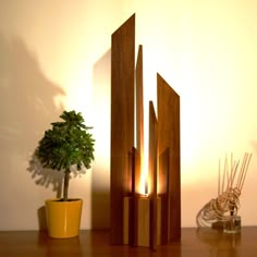 a potted plant sitting next to a wooden sculpture on top of a wood table