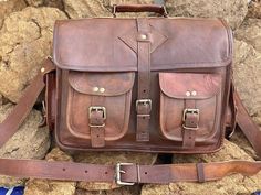 a brown leather bag sitting on top of a pile of rocks