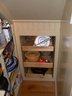 an open pantry with dishes and bowls in it