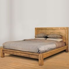 a bed sitting on top of a hard wood floor next to a white wall and wooden floors