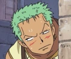 an anime character with green hair is looking at the camera while leaning against a brick wall