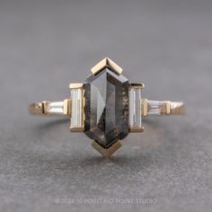 a fancy ring with an unusual shaped stone and two baguets on each side