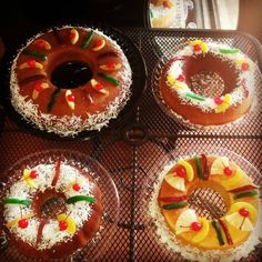 four cakes decorated with pineapples and other fruit