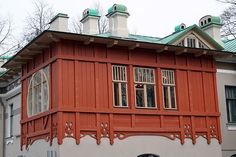 an orange house with green roof and windows