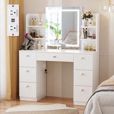 a white desk with drawers and a mirror on it in a room next to a bed