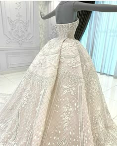 a mannequin is dressed up in a white gown with intricate lace and beading