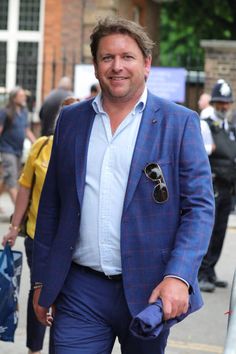 a man in a blue suit is walking down the street