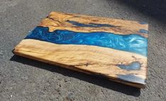 a piece of wood that has been painted blue and is laying on the ground next to a car