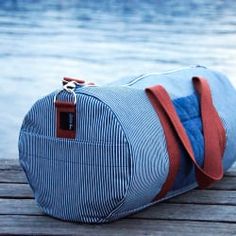 a blue and white duffel bag sitting on top of a wooden dock