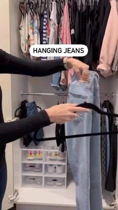 two women are trying to hang jeans in the closet