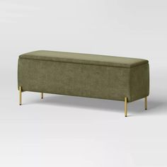 an upholstered bench with wooden legs and a green fabric cover on the back