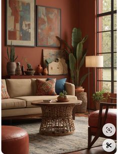 a living room filled with lots of furniture and paintings on the wall next to a window