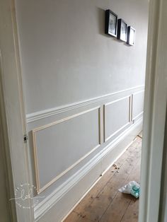 an empty room with white walls and wood flooring in the process of being painted