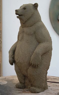 a statue of a bear sitting on top of a wooden table