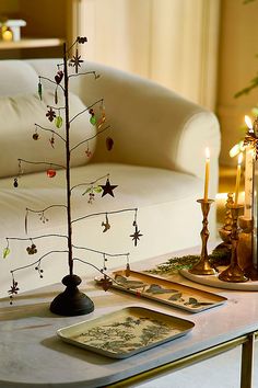 a small christmas tree sitting on top of a coffee table next to a white couch