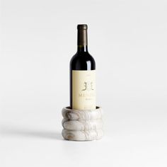 a bottle of wine sitting on top of a marble holder