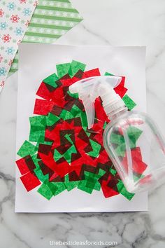 a hand sanitizer on top of a piece of paper next to a christmas wreath