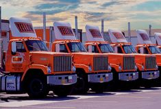 a row of orange trucks parked next to each other