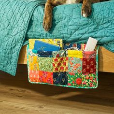 a dog laying on top of a bed next to a green comforter and pillows